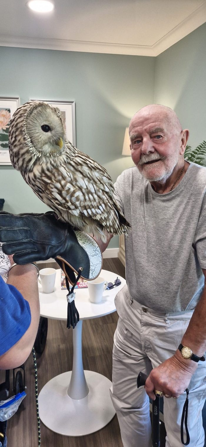 Bingley Park resident smiling beside a barn owl during an interactive Owl Adventures animal experience.