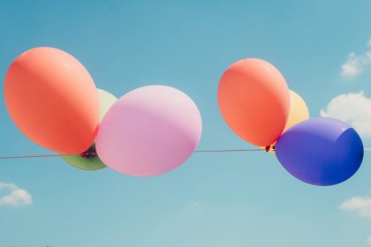 Colorful balloons float under a clear blue sky
