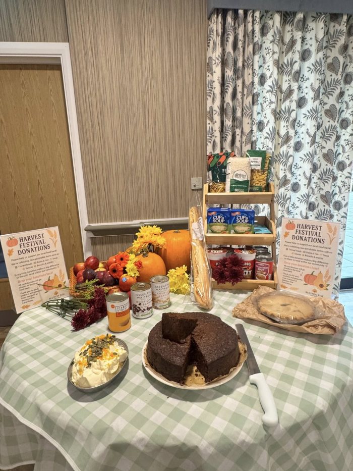 Harvest Festival display at Beeston Rise featuring donated food items, seasonal produce and homemade cakes collected to support the local food bank.