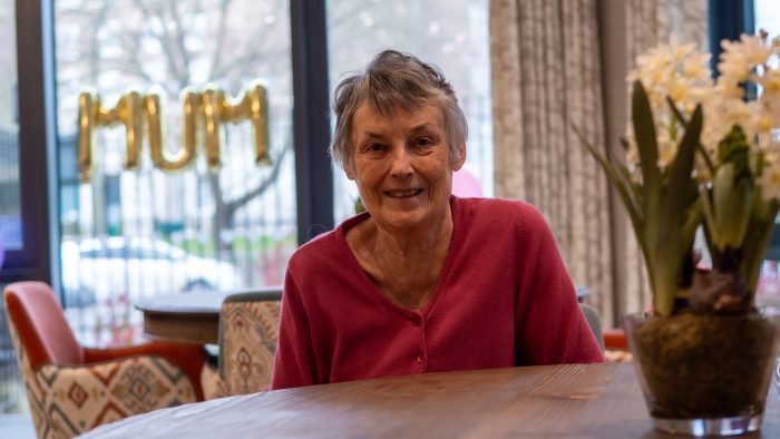 A happy resident in the bright, modern dining area at Trent Bridge Care Home, Nottingham