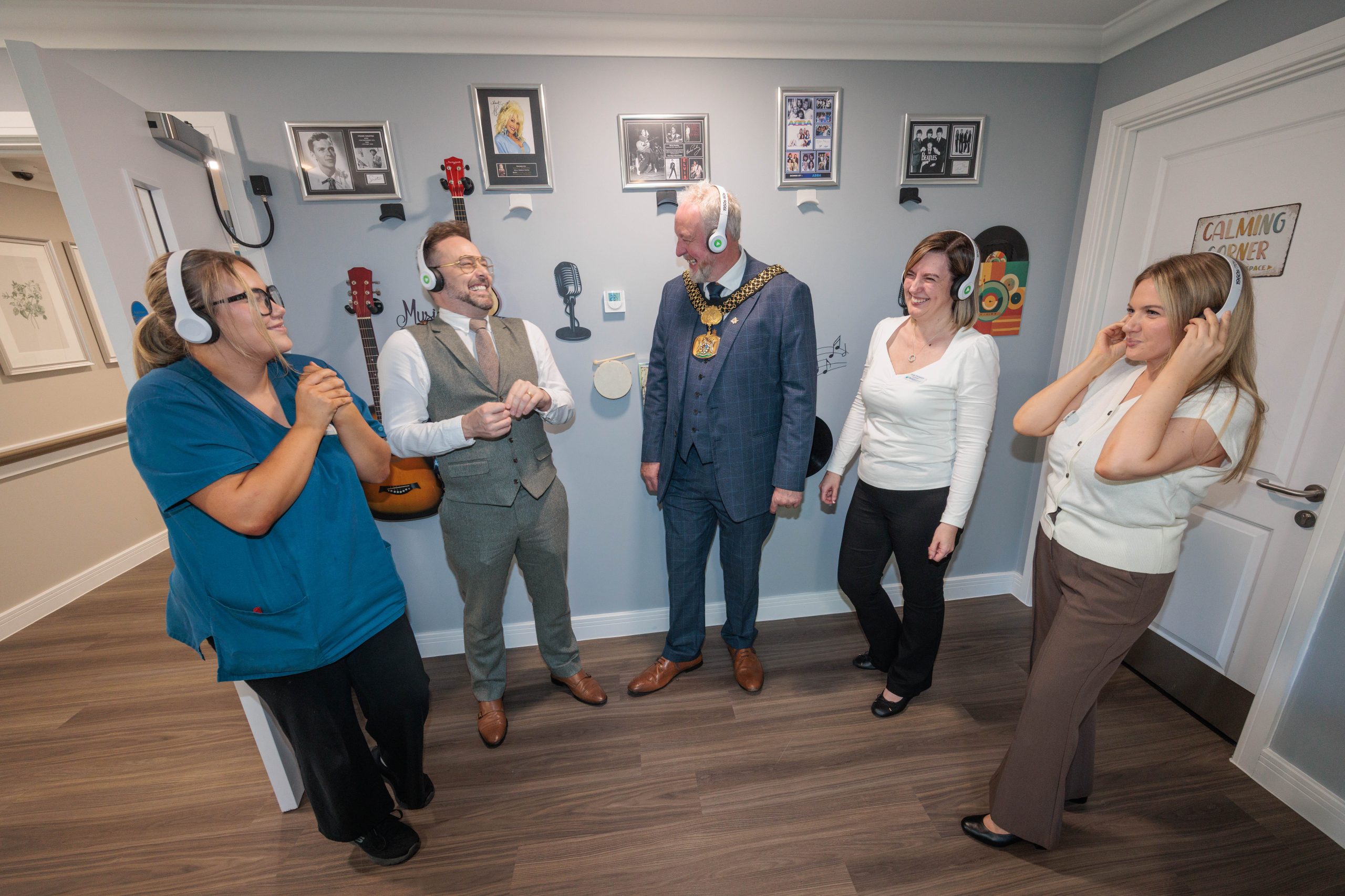 Three residents seated with the Lord Mayor of Bradford and care team members in a lounge at Bingley Park Care Home.